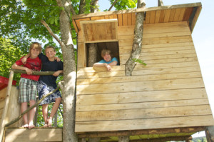 Kinder posieren im Baumhaus