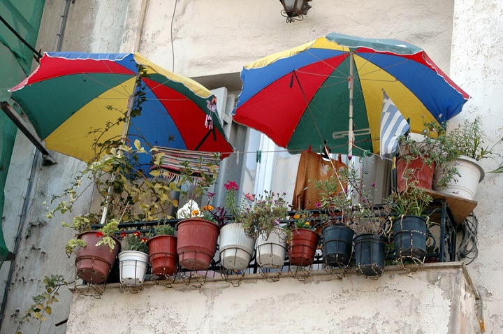 Alter Balkon mit bunten Schirmen