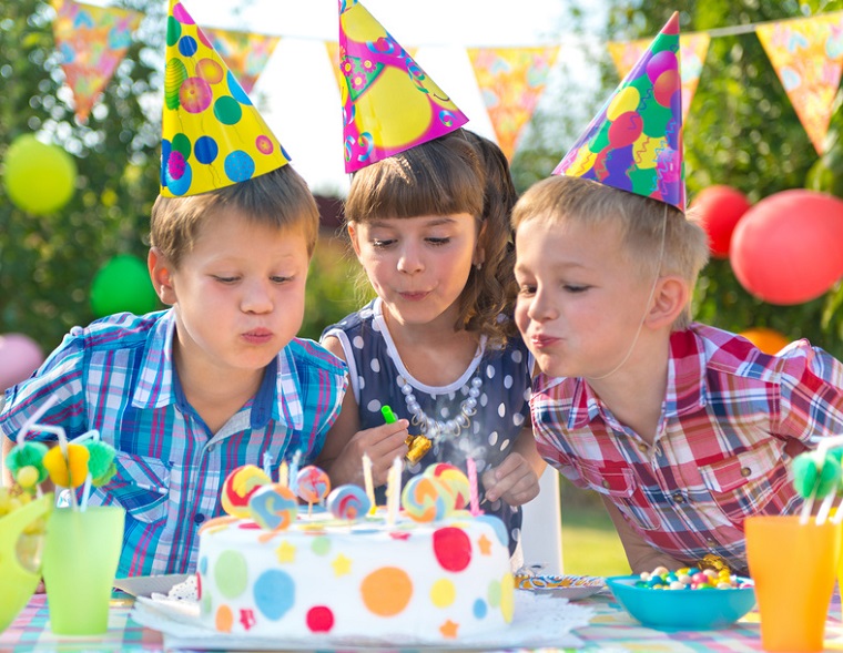 Kindergeburtstag: Kinder pusten Kerzen aus