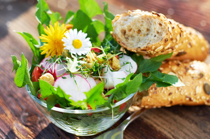 Knackiger Frühlingssalat mit Wildkräutern Knackiger Frühlingssalat mit essbaren Blüten und Baguette-Stangen